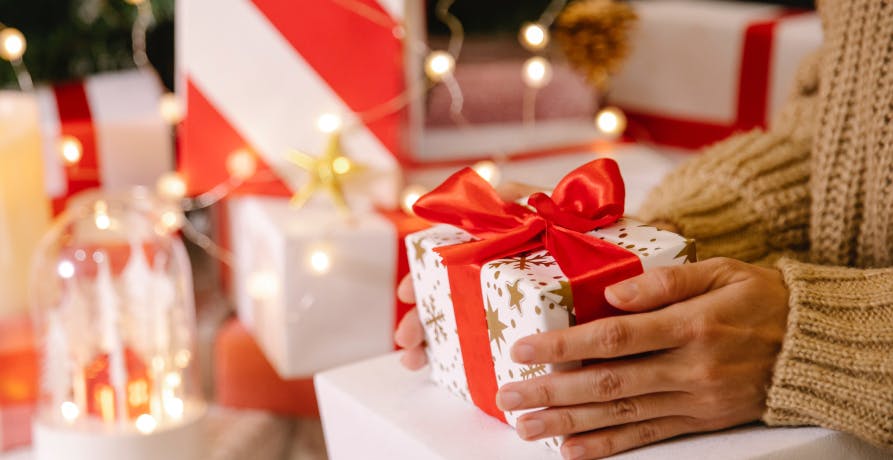 une personne qui tient un cadeau entre ses mains