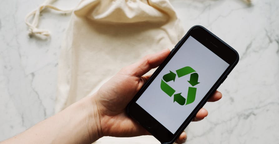 logo recyclage sur un écran de téléphone tenu par une main