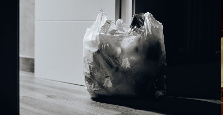un sac en plastique contenant des déchets posé devant une porte