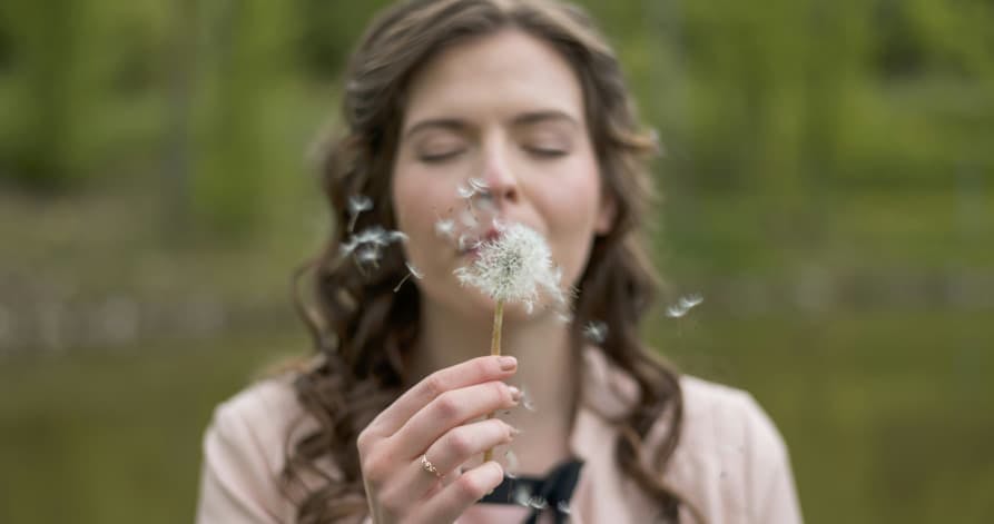 person making a wish with dandelion