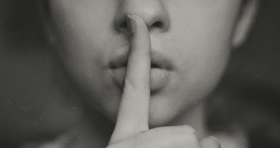 person shhh with index finger over lips