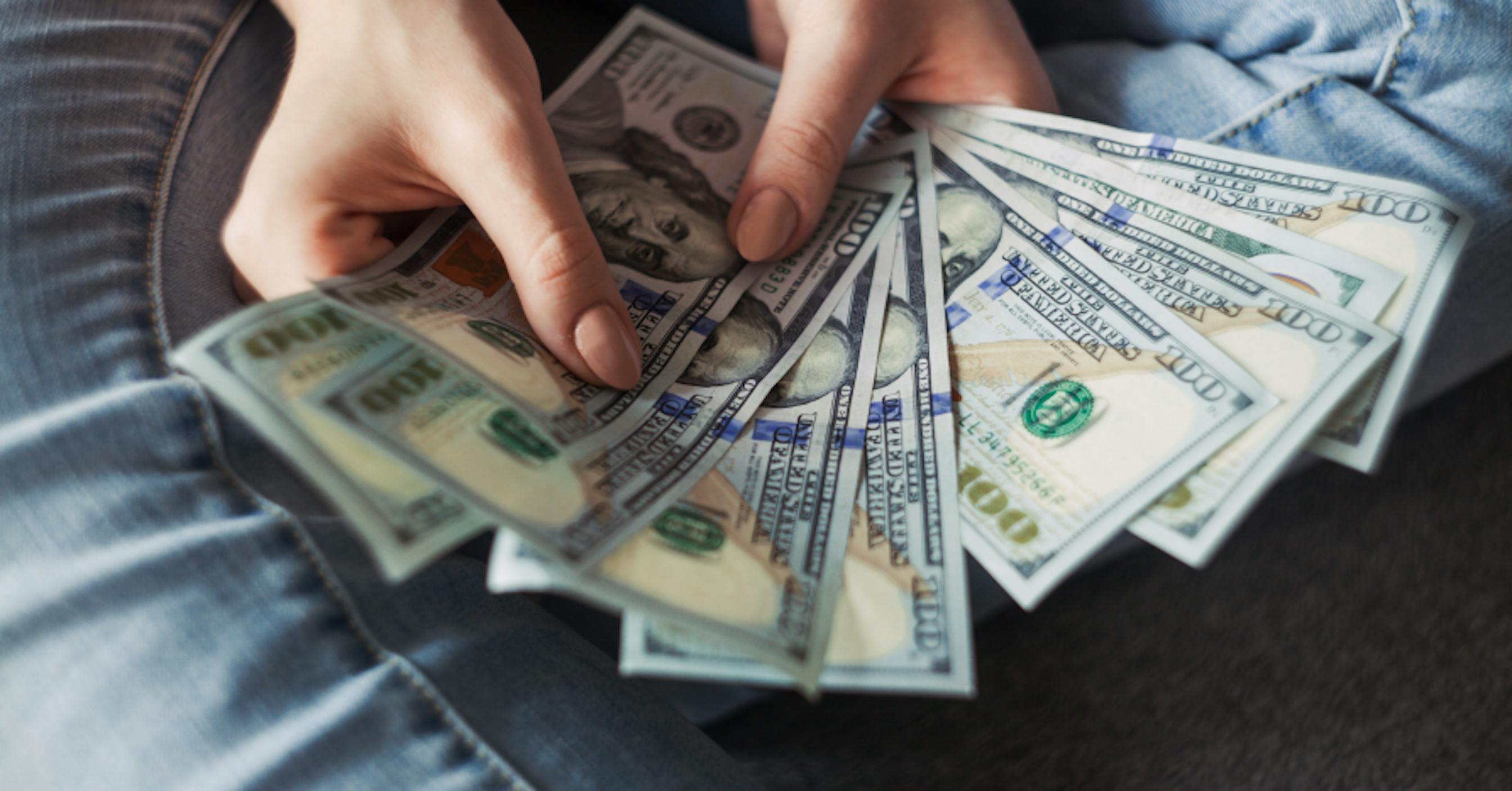 person holding $100 bills USD