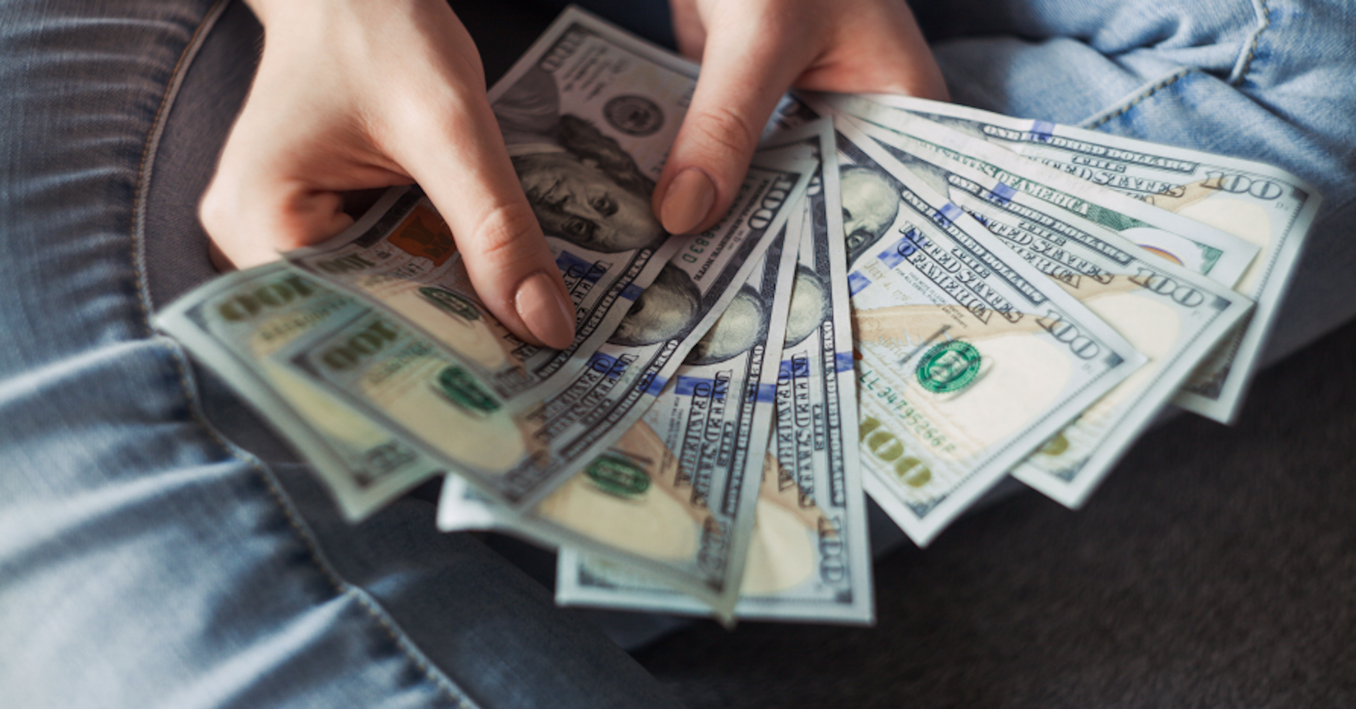 person holding $100 bills USD