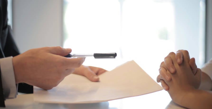 man holding legal document and pen