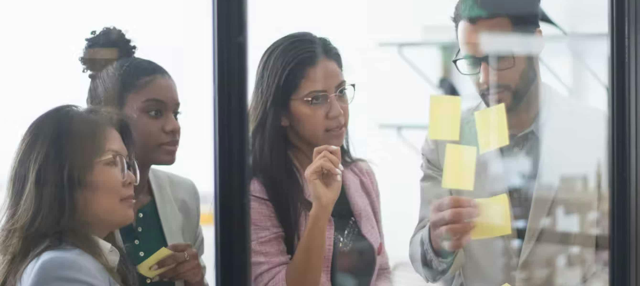 personnes devant une vitre avec des post-it