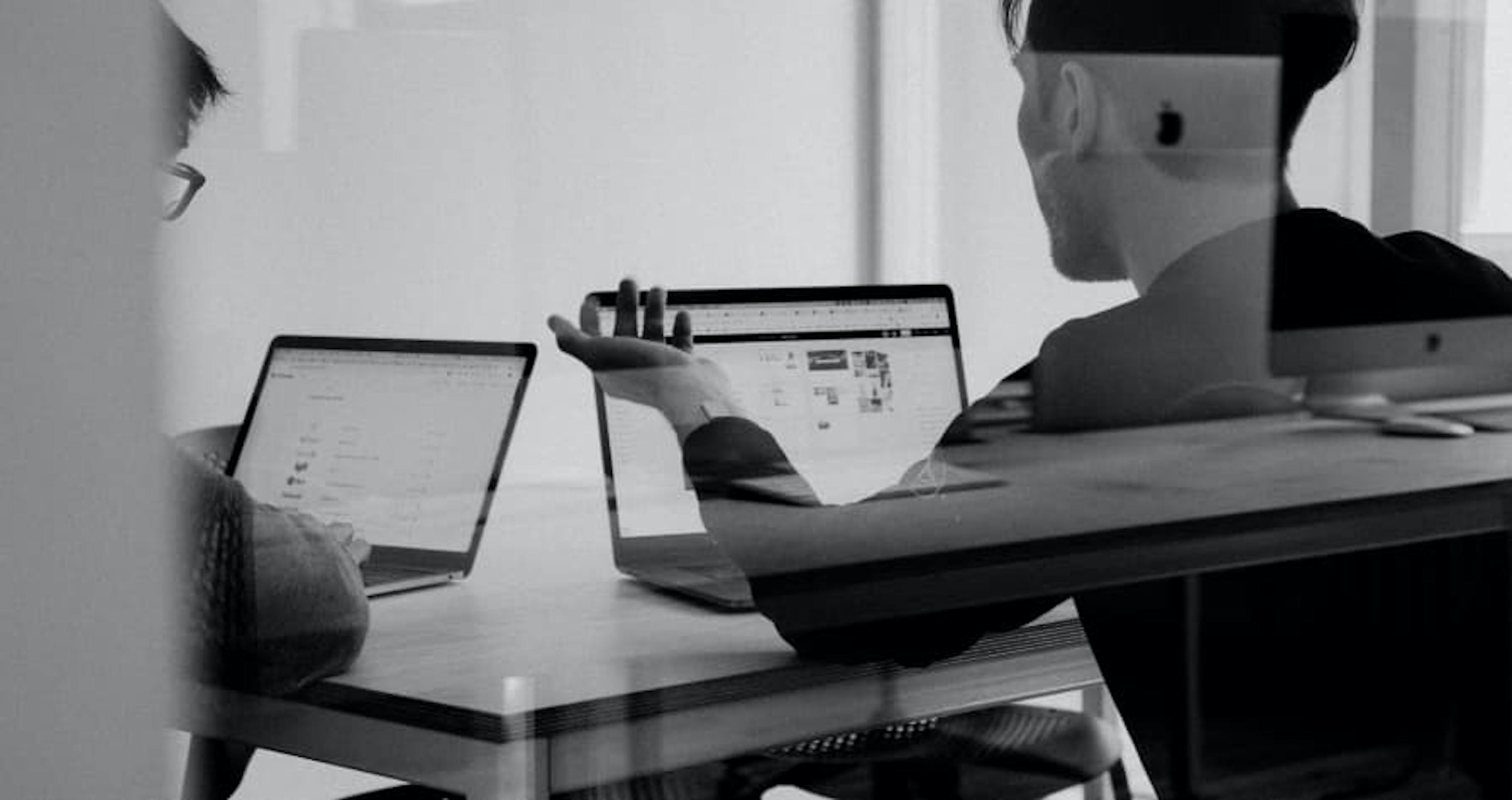 black and white photos people sitting at desk