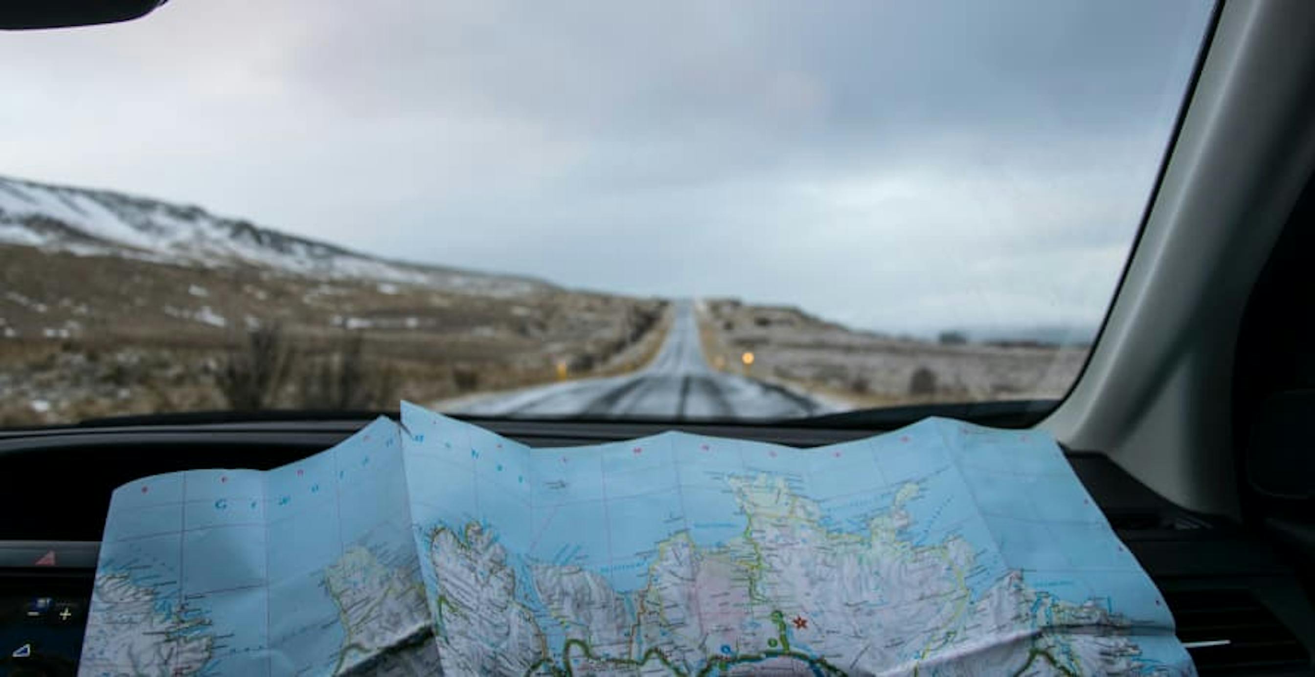 looking at map in car in barren land