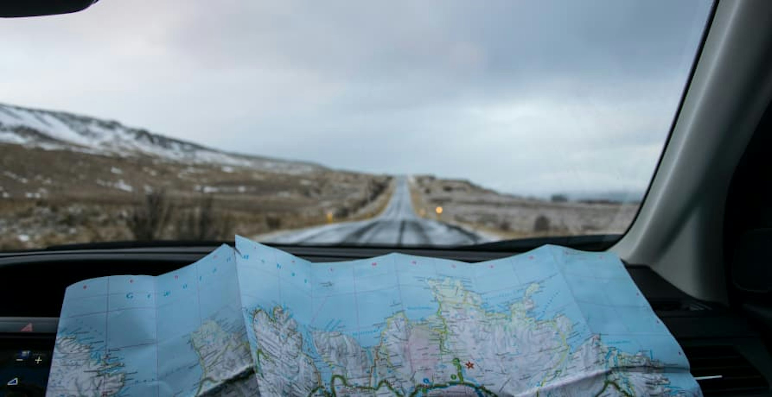 looking at map in car in barren land