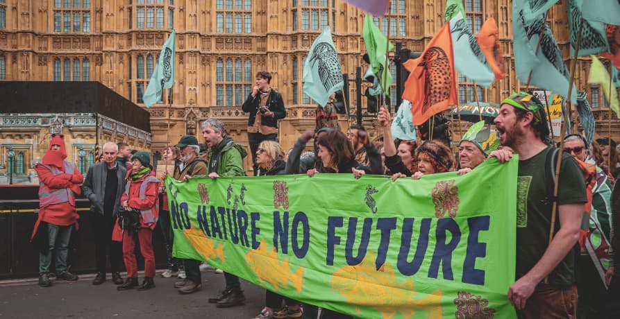 Climate change activists holding a banner in front of Westminster