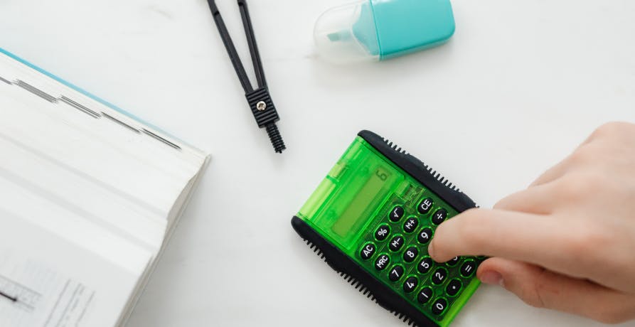 person with small green calculator 