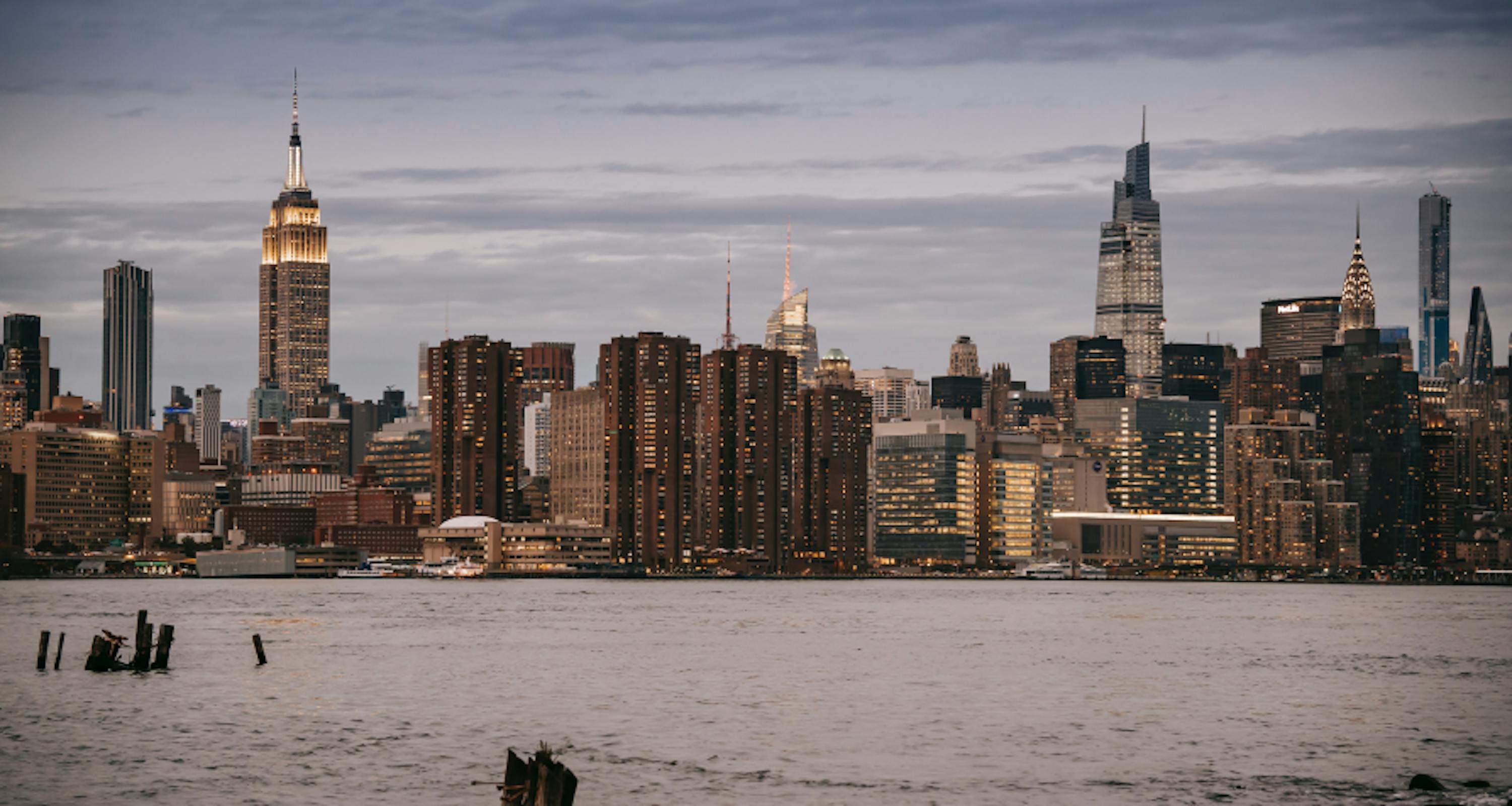 NYC skyline and view of empire state building from hudson river pier