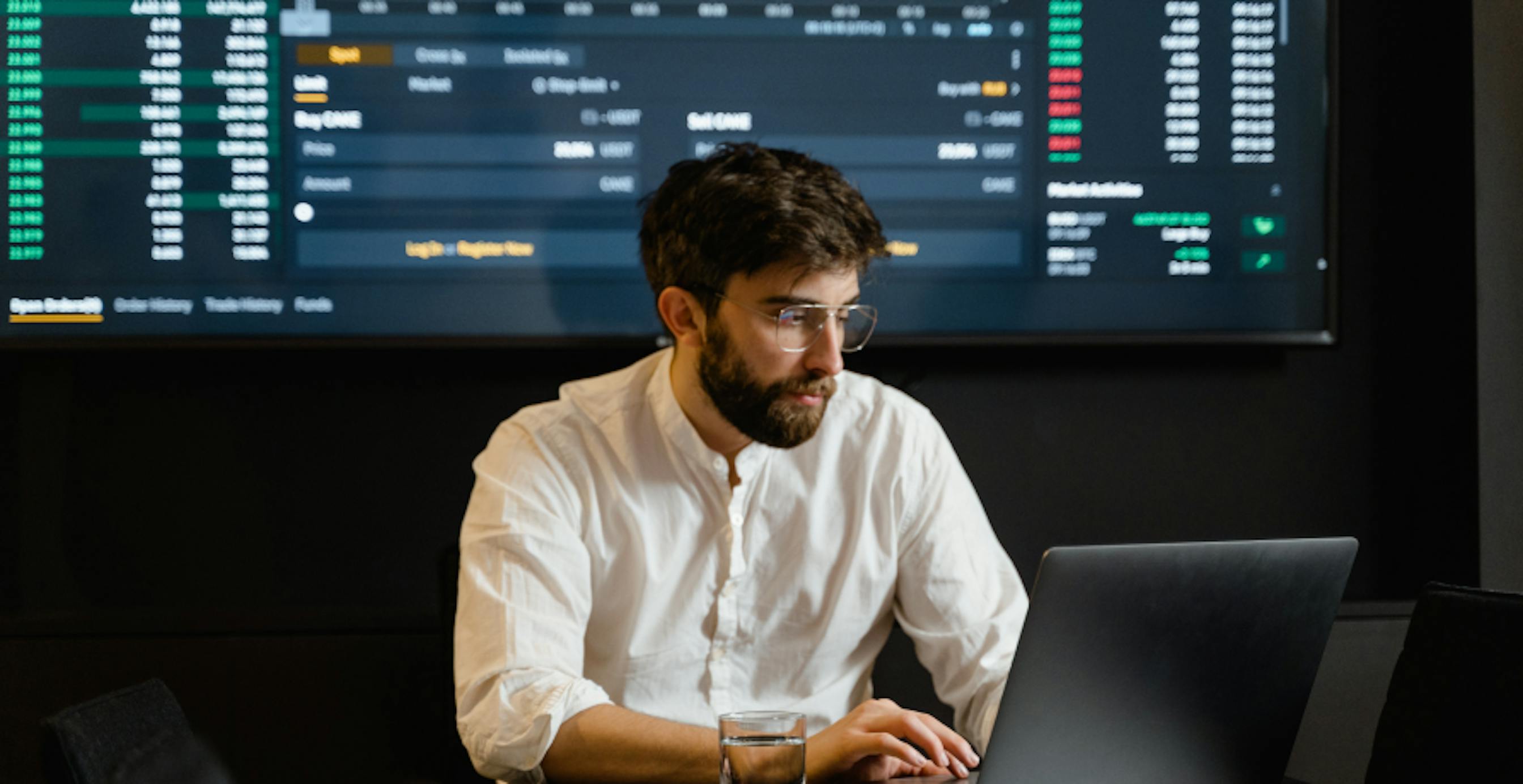 trader sitting in front of screen with investment data