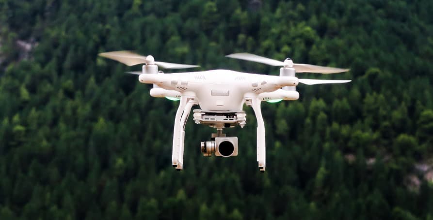white drone in forest