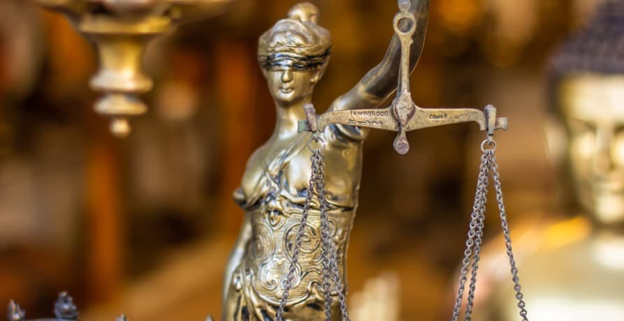 Image of bronze lady justice statue holding a set of scales