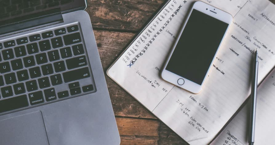 laptop and iphone with notepad