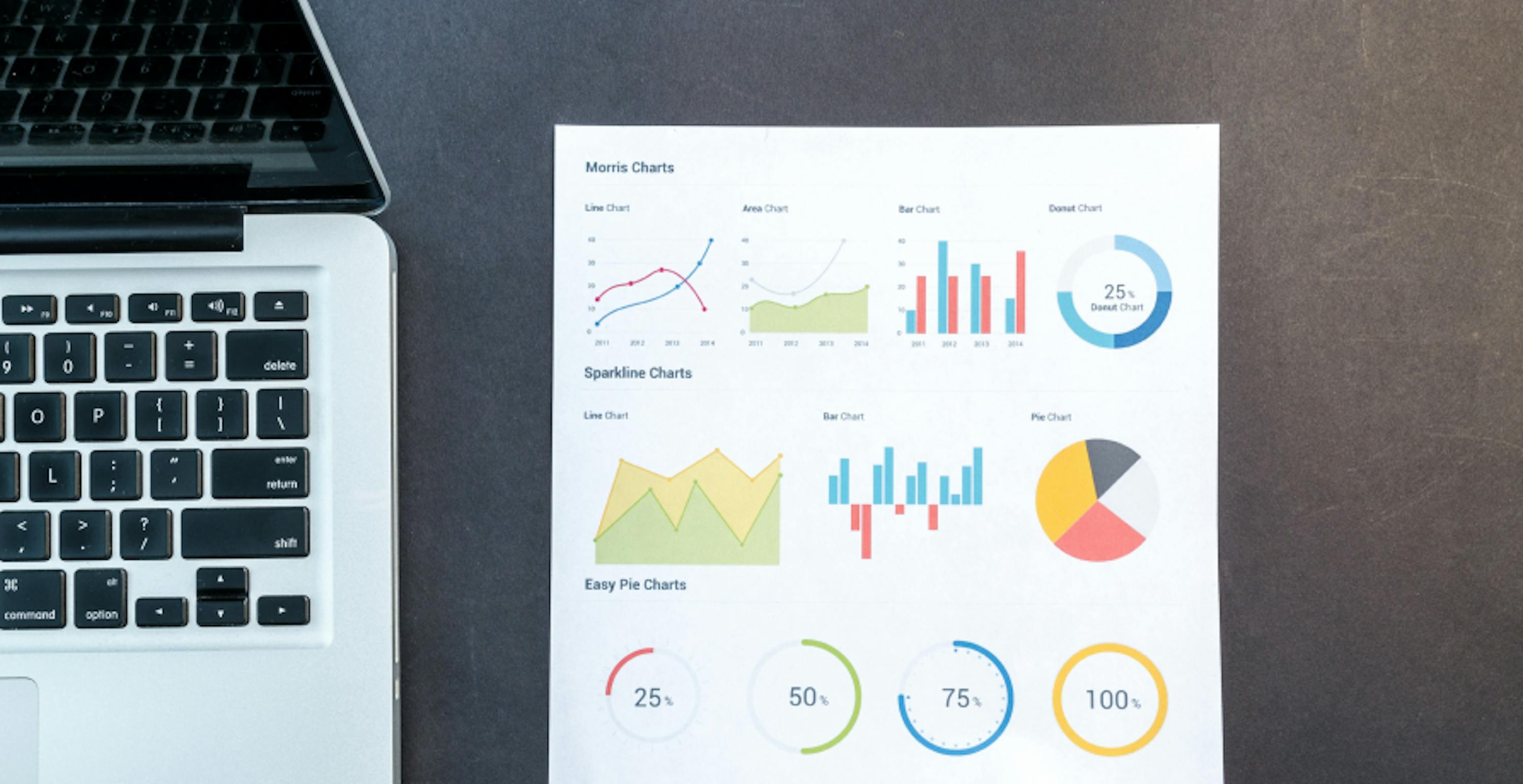 un ordinateur portable ouvert à côté d'une feuille papier indiquant plusieurs statistiques