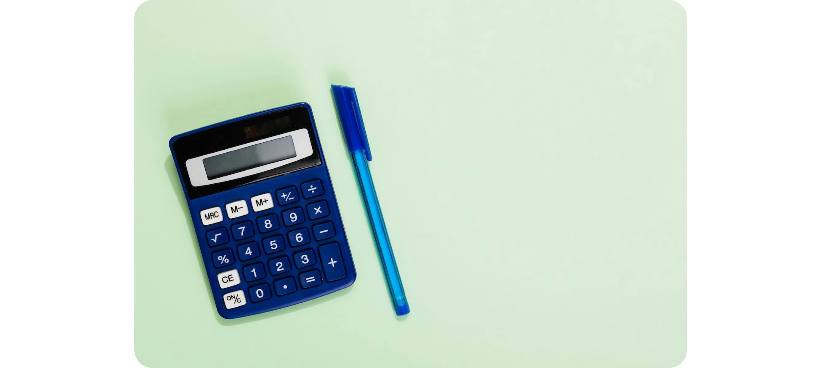 Une calculatrice bleue et noire et un stylo sur une surface vert clair