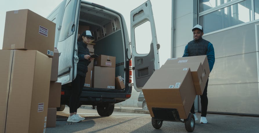 two men with a van unloading boxes of goods
