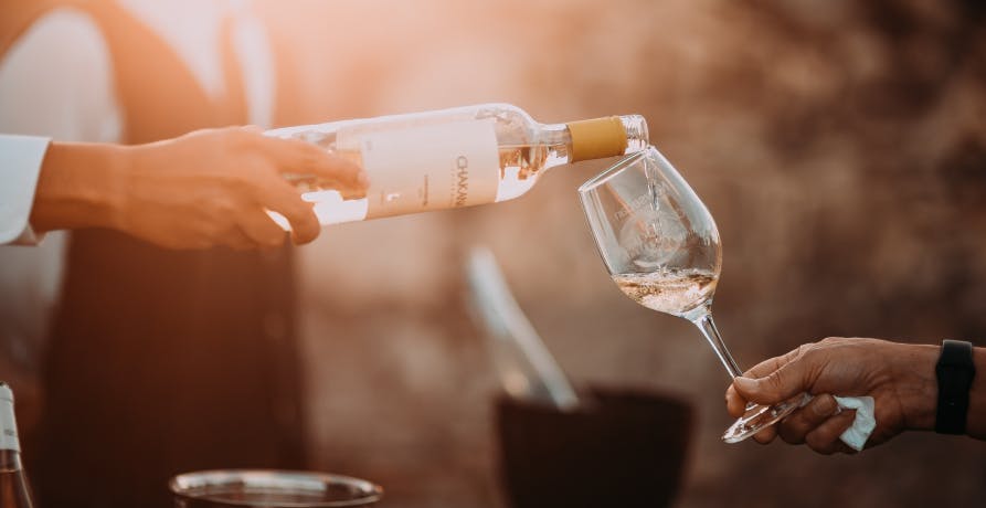 une personne qui sert un verre de vin