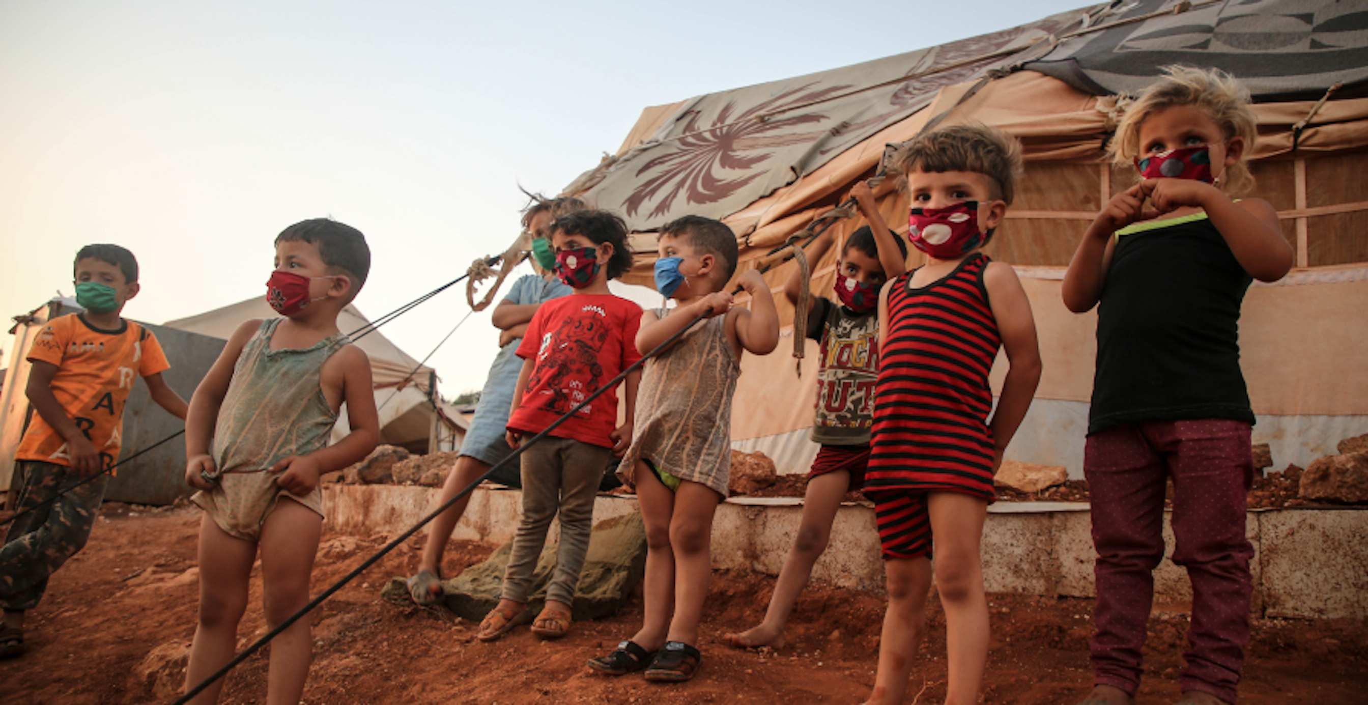 refugee camp with children in front of tents