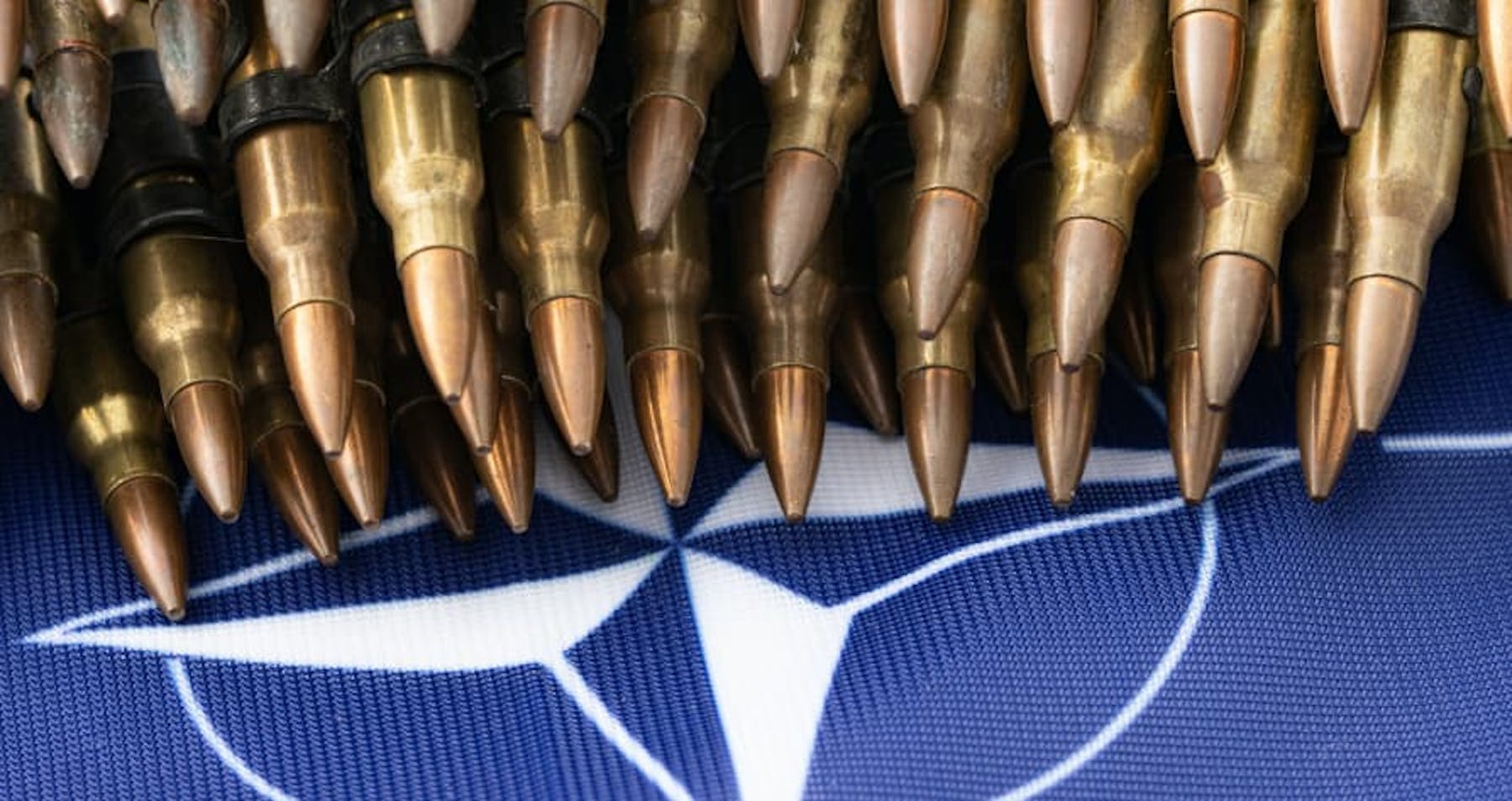pile of pens on top of NATO flag