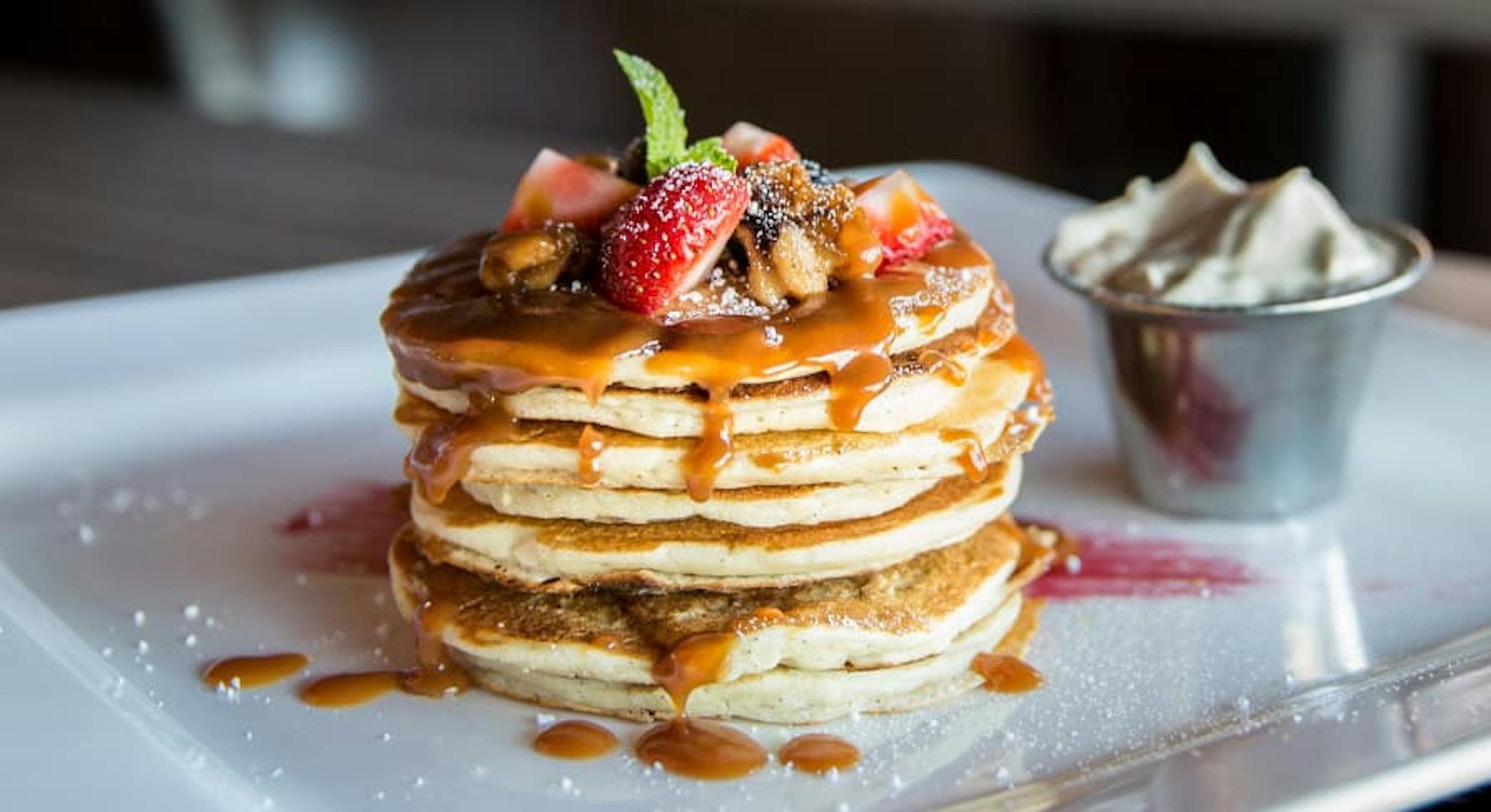 pancakes with berries and whipped cream on side