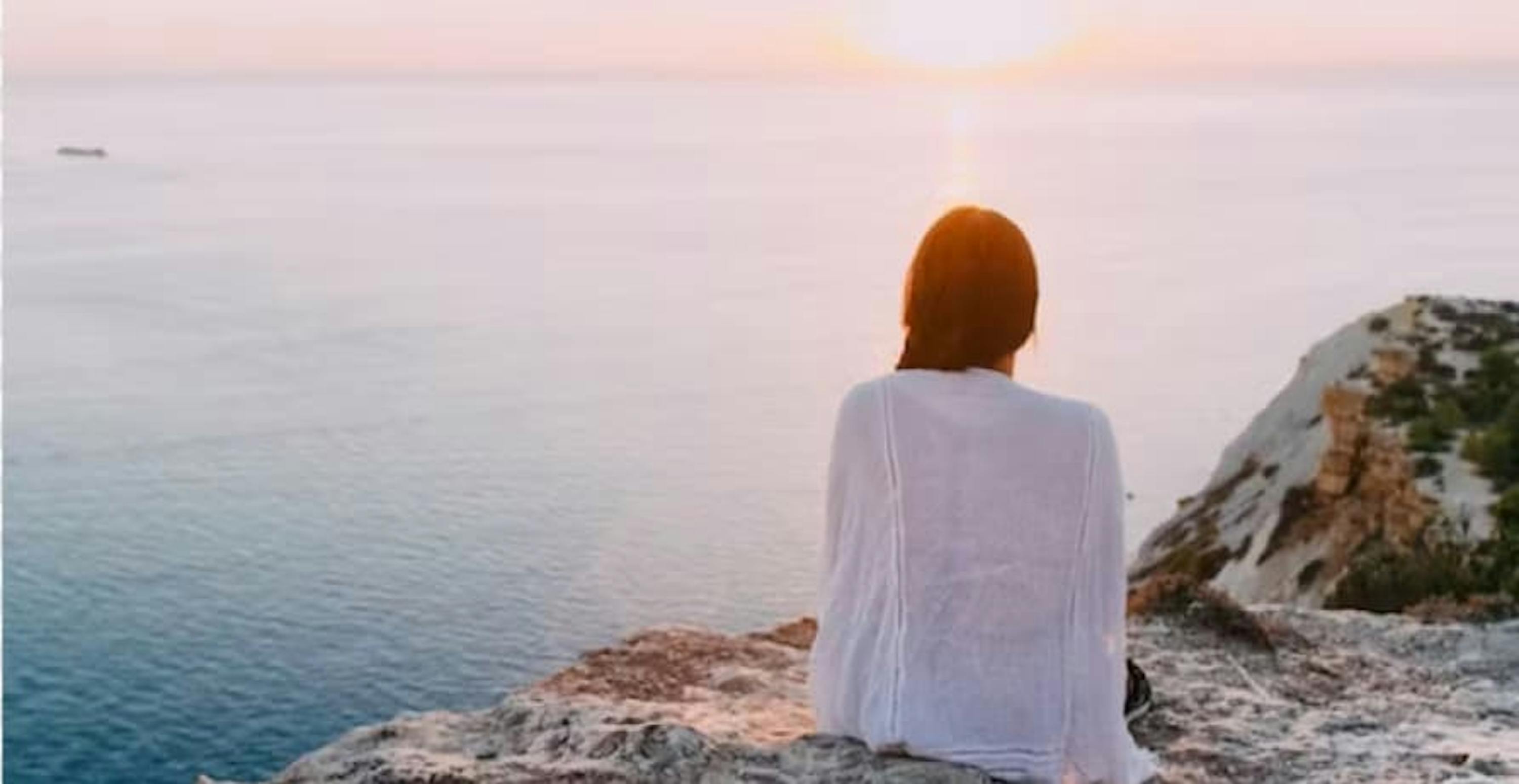 person watching sunset on rock