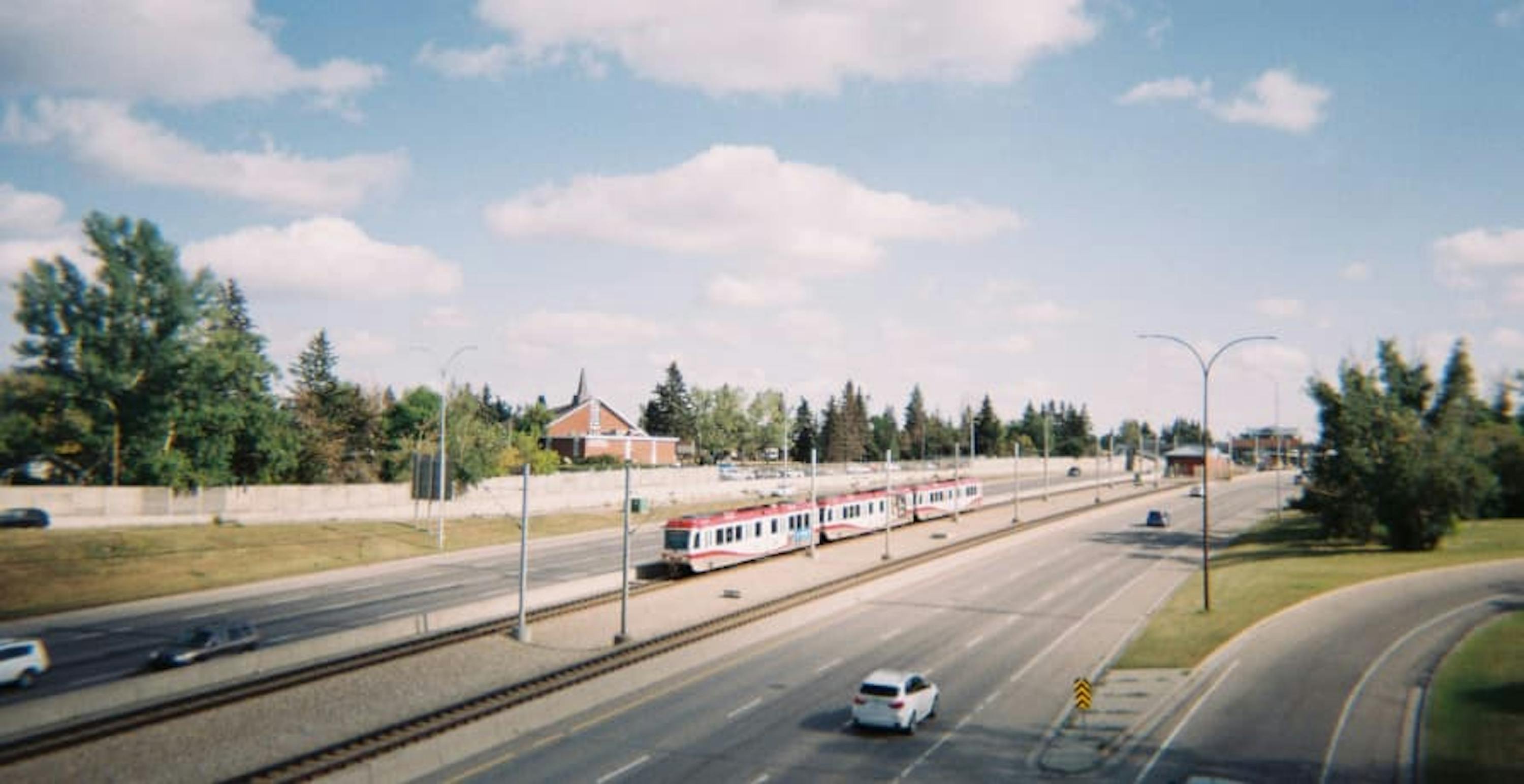 train driving next to road with car on it