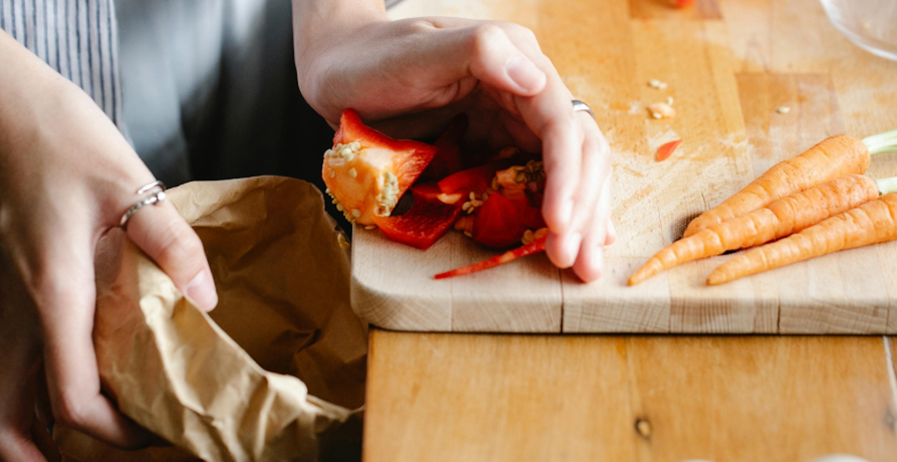 déchets alimentaires amassés au bord d'une table pour être jetés dans un sac