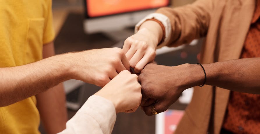 quatre personnes faisant un check du poing