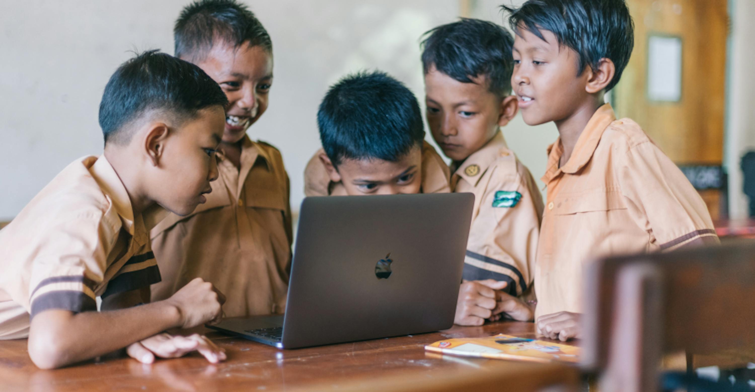 young students around laptop