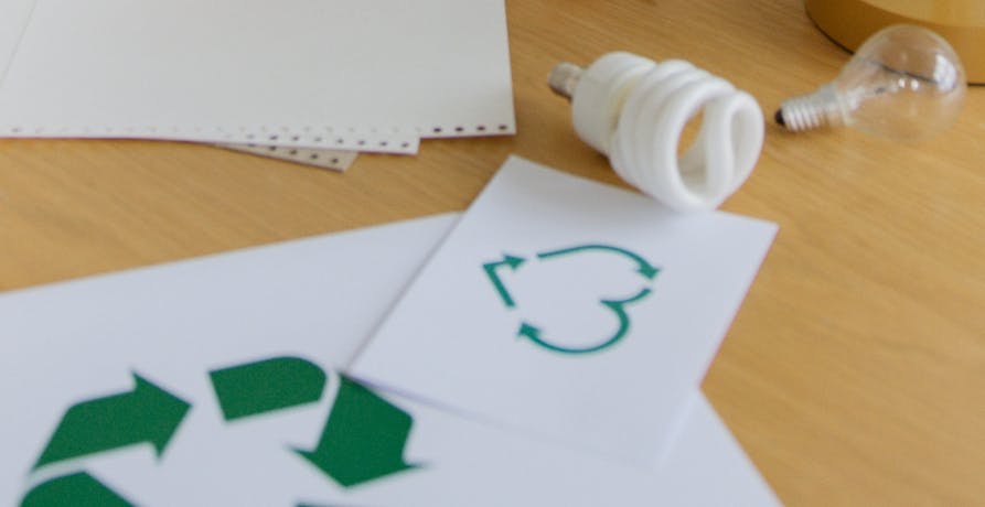 deux papiers avec le logo du recyclage dessus