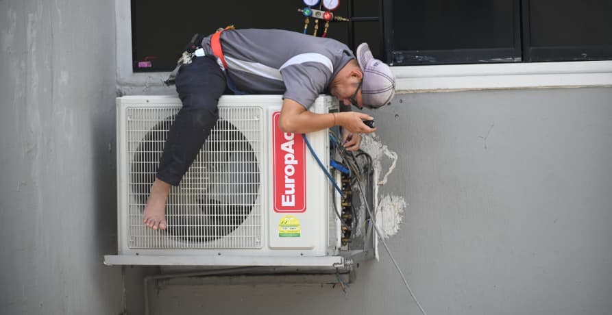man fixing an air conditioning unit