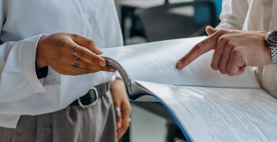 une personne montrant du doigt un document papier