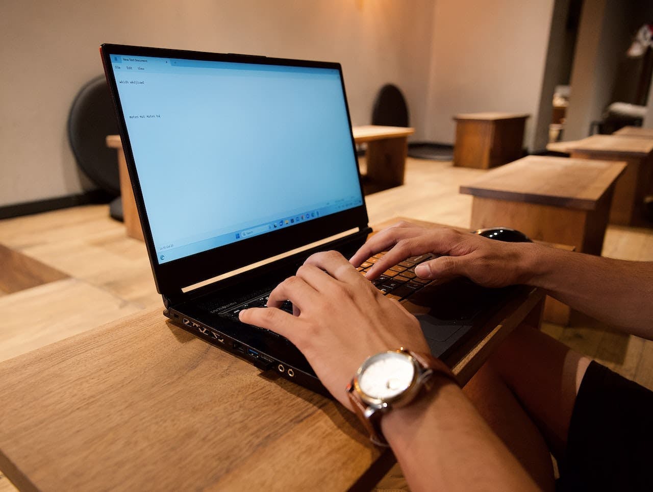une personne tapant un texte sur un ordinateur portable à un bureau