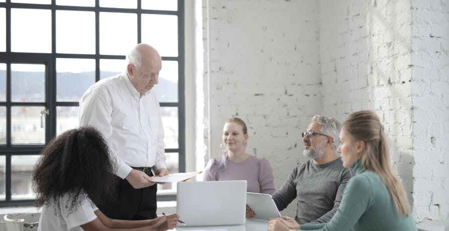 office meeting with employees and man standing up presenting