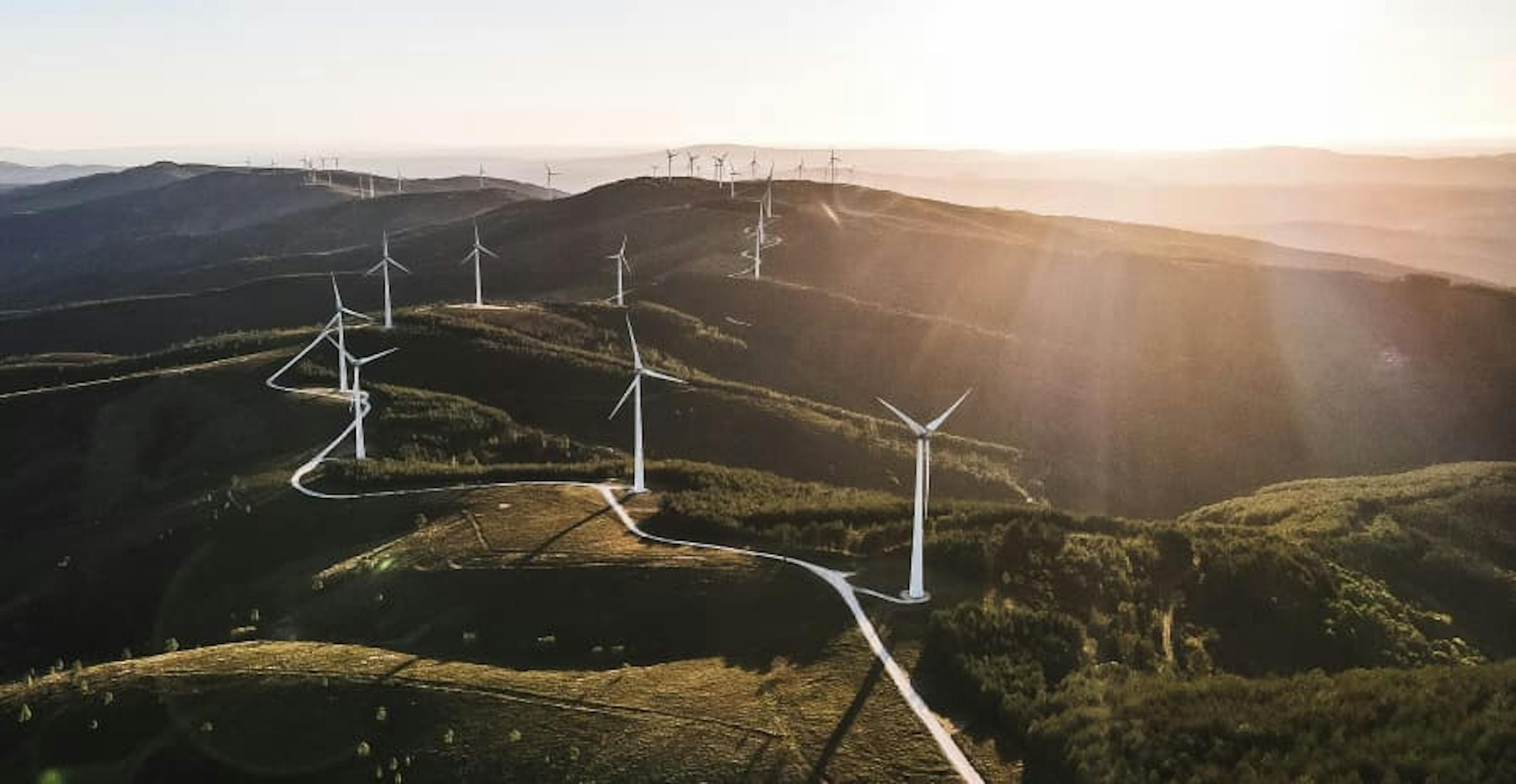 wind farm across hills and sunrising 