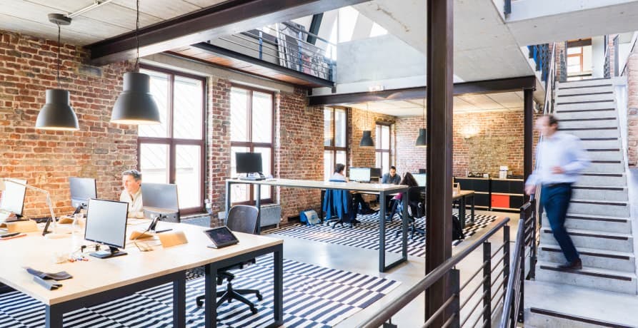 man walking through a modern open plan office space