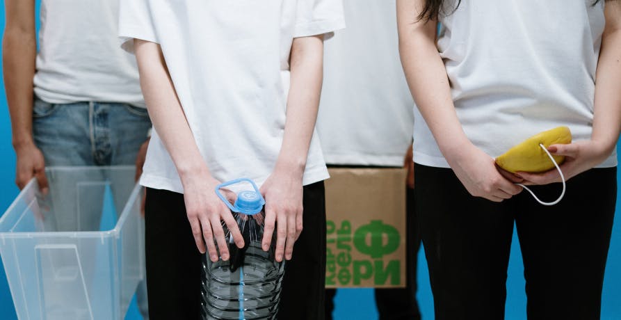 four people holding recycling items