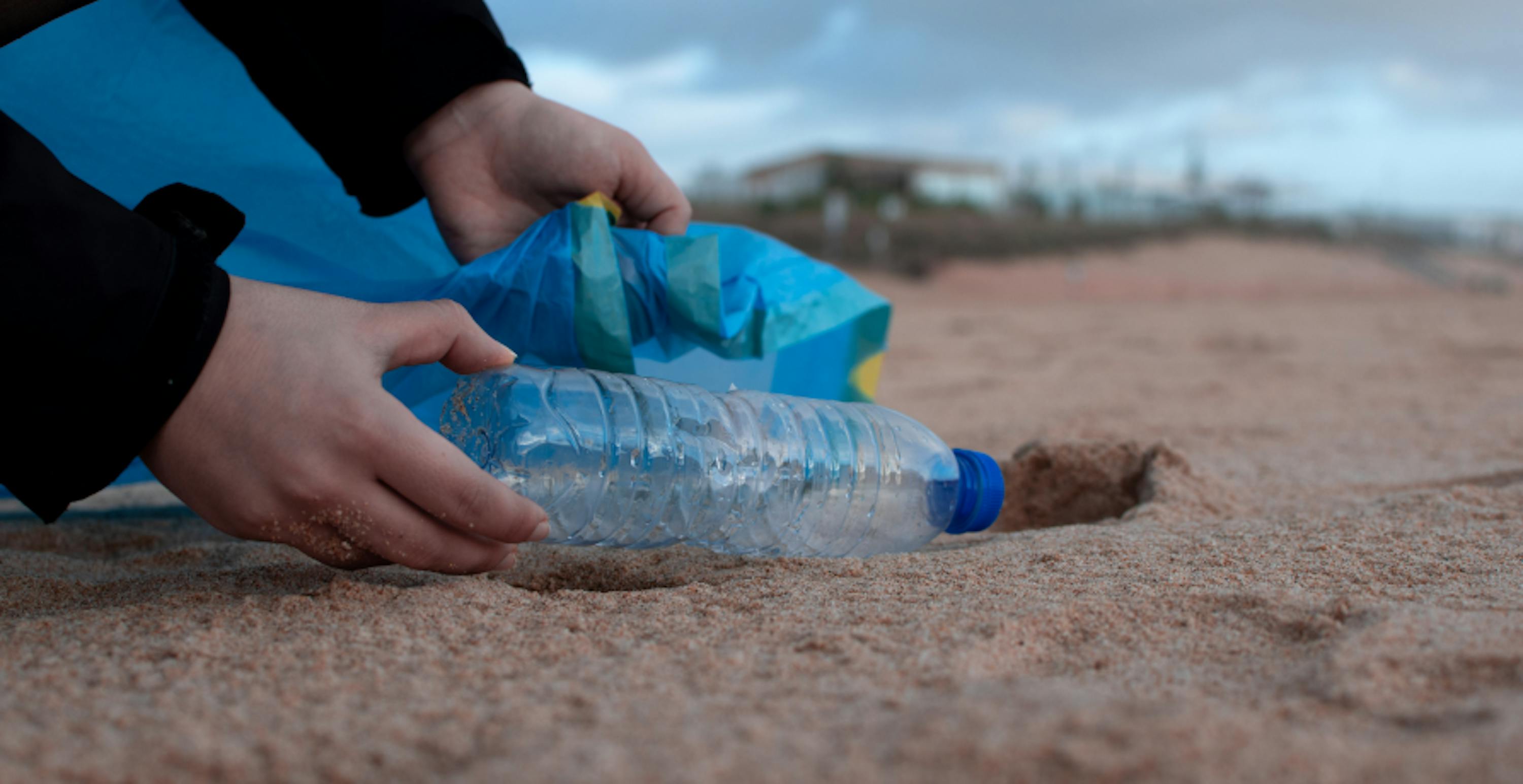 someone picking up litter on the beach