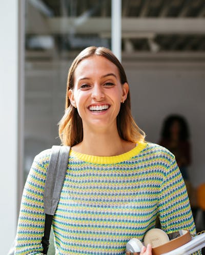 Woman smiling, wearing a bag and an headphone