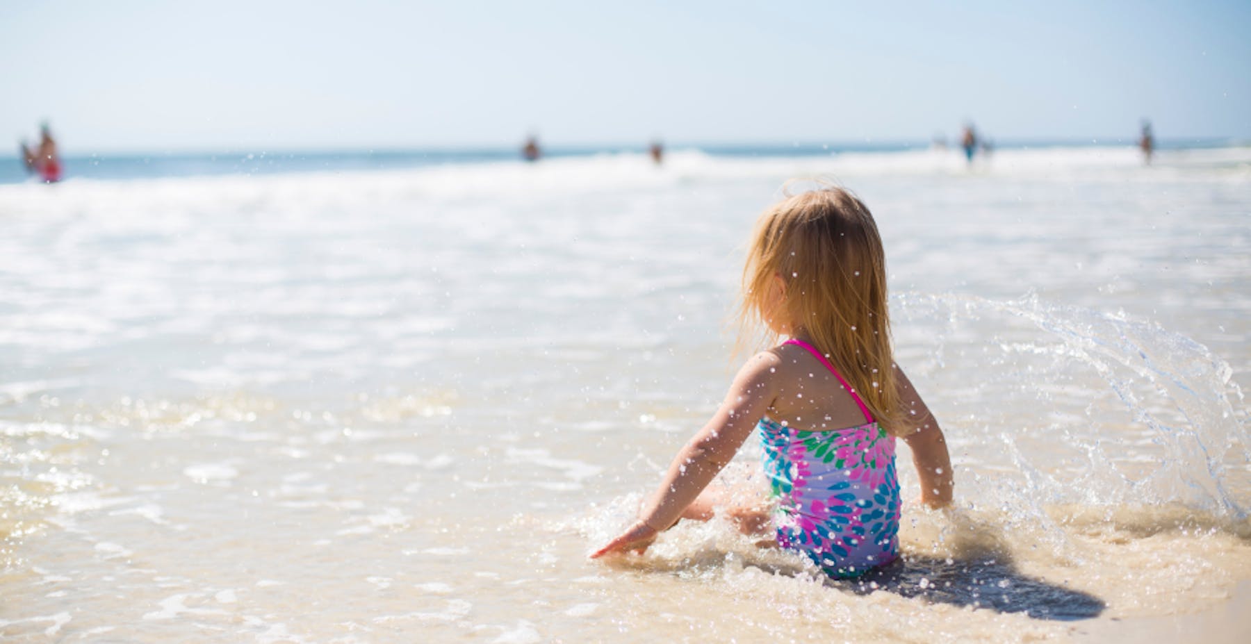 little girl sitting on the beach