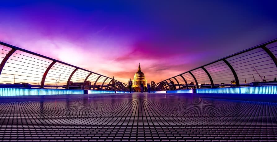 Saint Pauls Cathedral in London at night and a pedestrian bridge over the River Thames