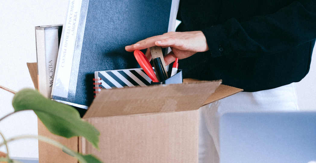 Someone placing belongings into cardboard box