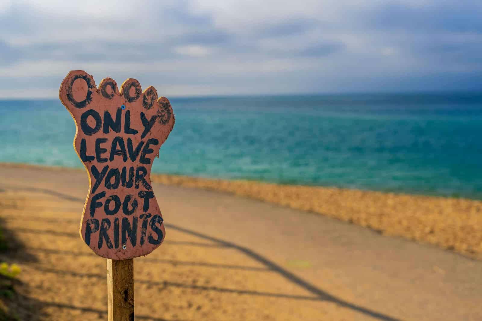 Une enseigne sur la plage only leave your foot prints