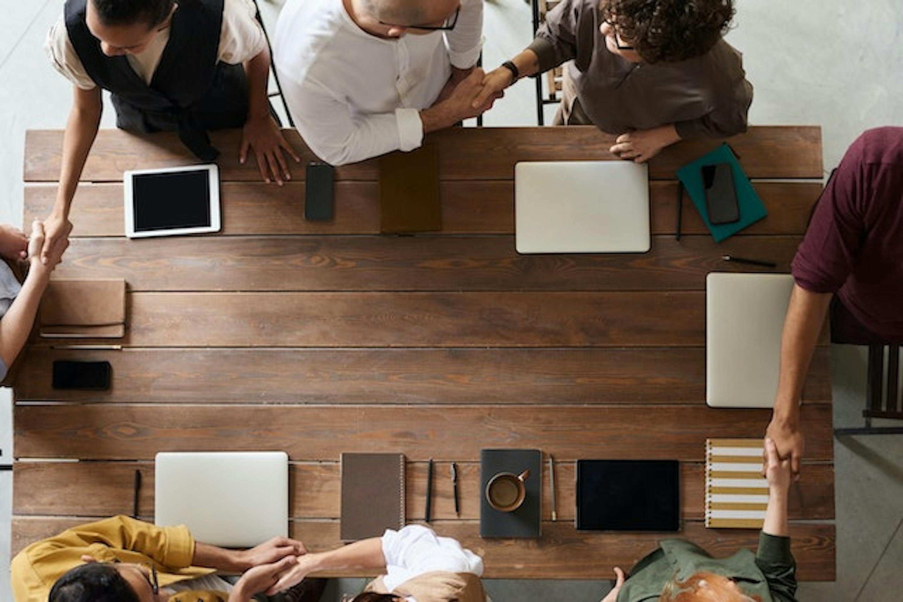 Des personnes se serrant la main autour d'une table