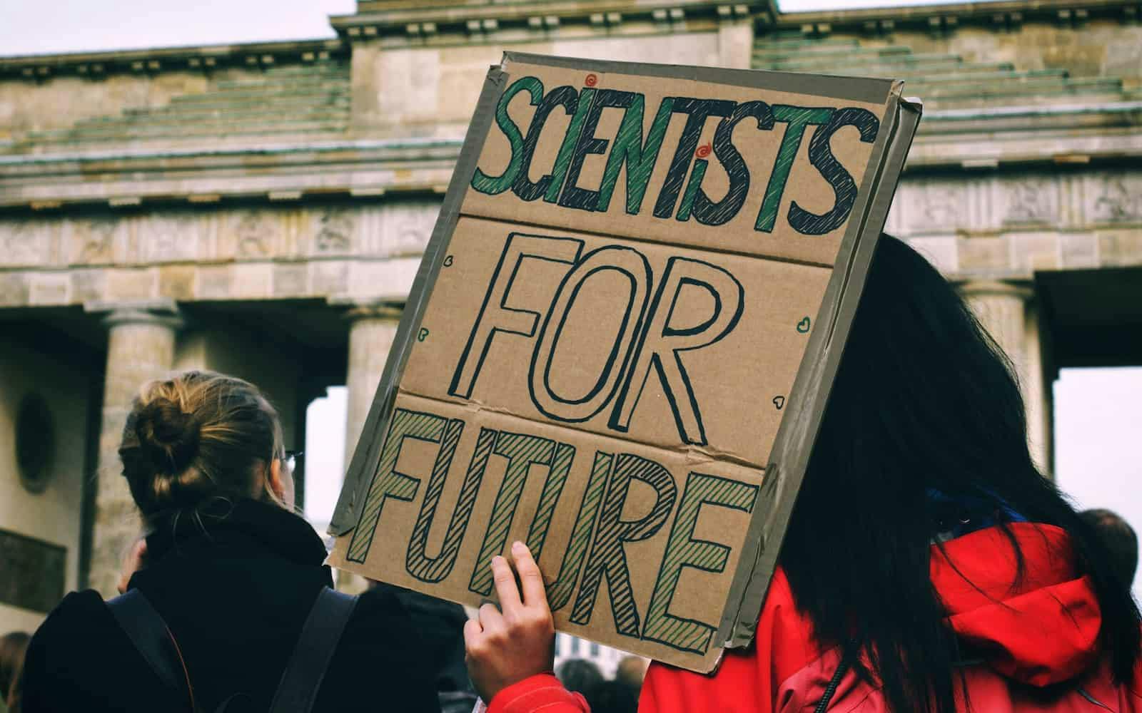 Une femme tenant une pancarte scientifiques pour le futur