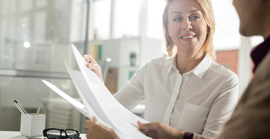 eine Frau die ein Dokument aushändigt