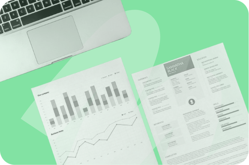 un ordinateur et des feuilles de papier avec des graphiques sur fond vert