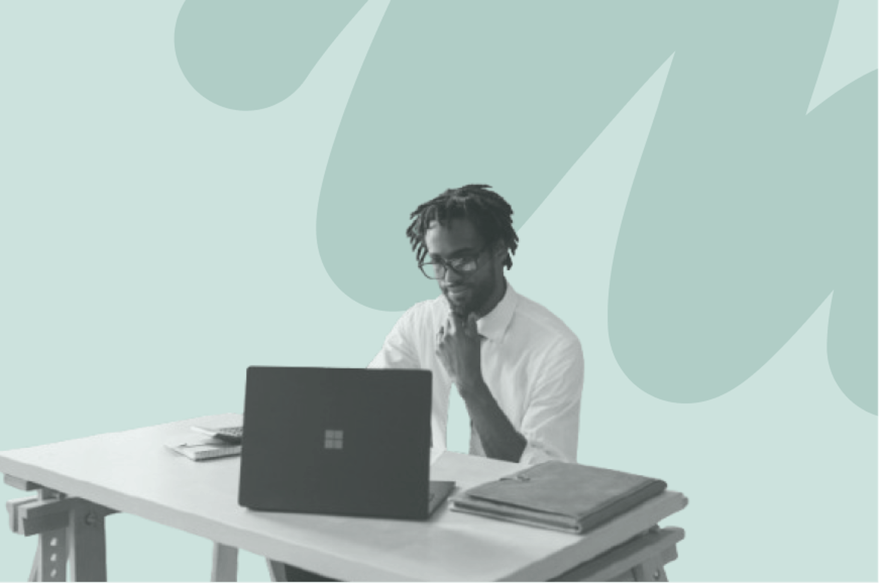 man sitting at office desk looking at laptop